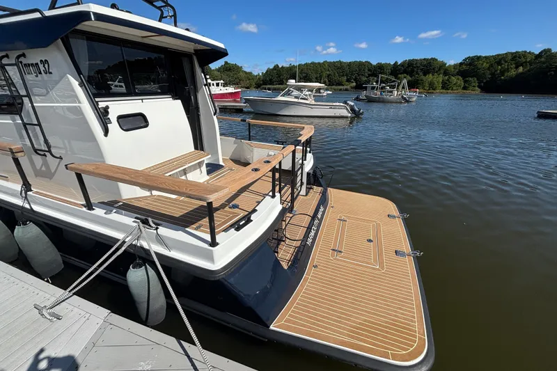 Slide: The Image of 2024 Targa 32 boat docked on a sunny day, showcasing sleek design and wooden deck. - 15