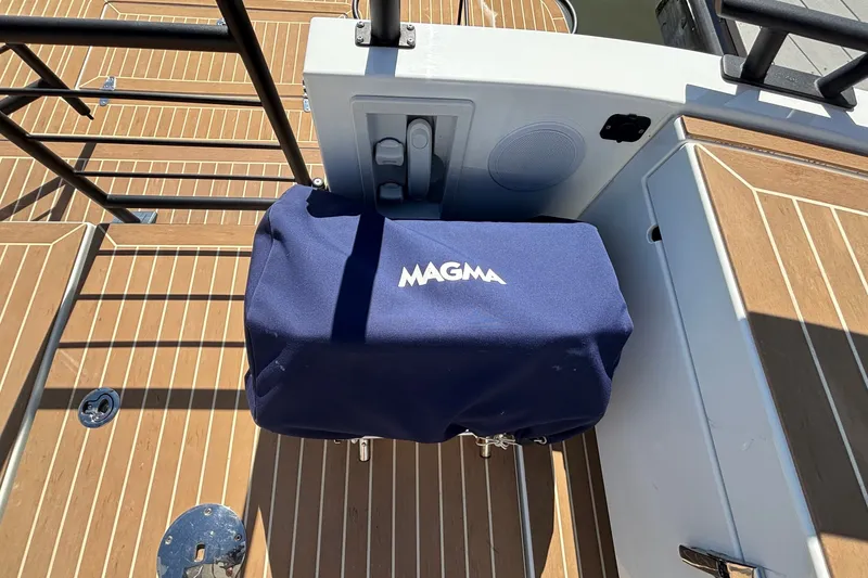 Slide: The Image of 2024 Targa 32 boat deck with Magma grill cover, featuring teak flooring. - 55