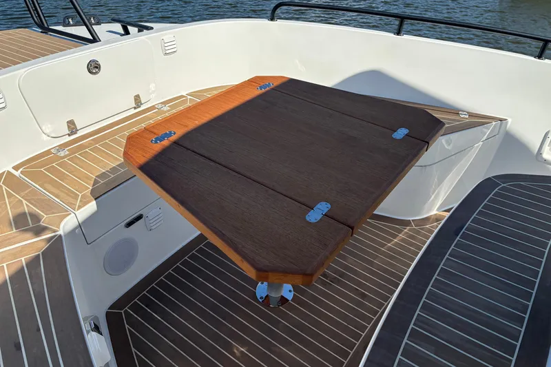 Slide: The Image of 2024 Targa 32 boat deck with wooden table and seating area. - 22