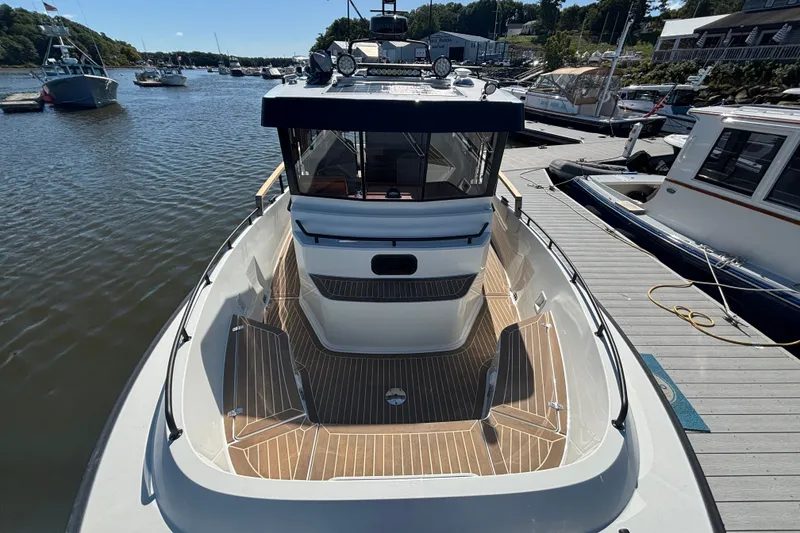 Slide: The Image of 2024 Targa 32 boat docked at marina, showcasing sleek design and spacious deck. - 18