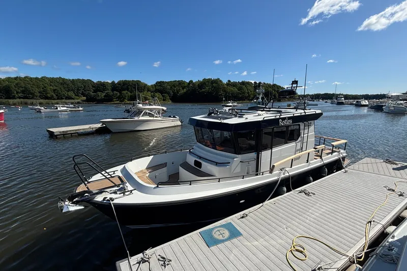 Slide: The Image of 2024 Targa 32 boat docked at a marina under a clear blue sky. - 9