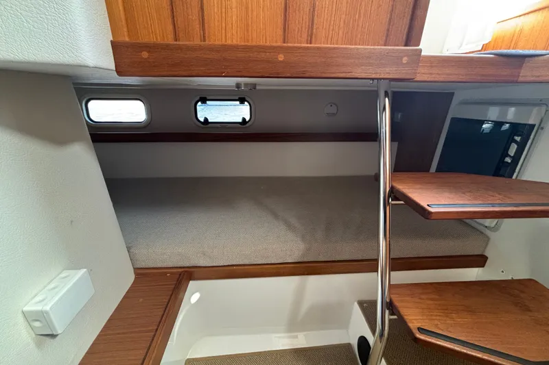 Slide: The Image of 2024 Targa 32 interior cabin with wooden steps and cozy sleeping area. - 52