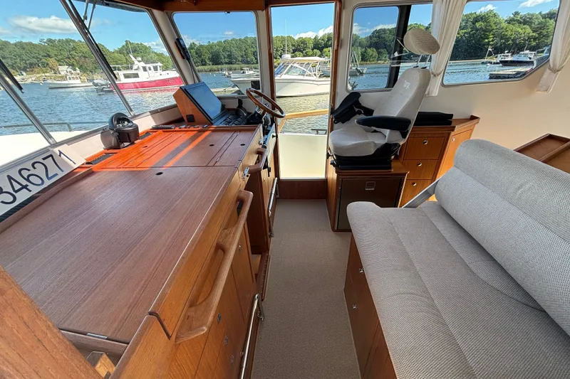 Slide: The Image of Interior of 2024 Targa 32 boat with wooden cabinetry and seating, docked by the water. - 31