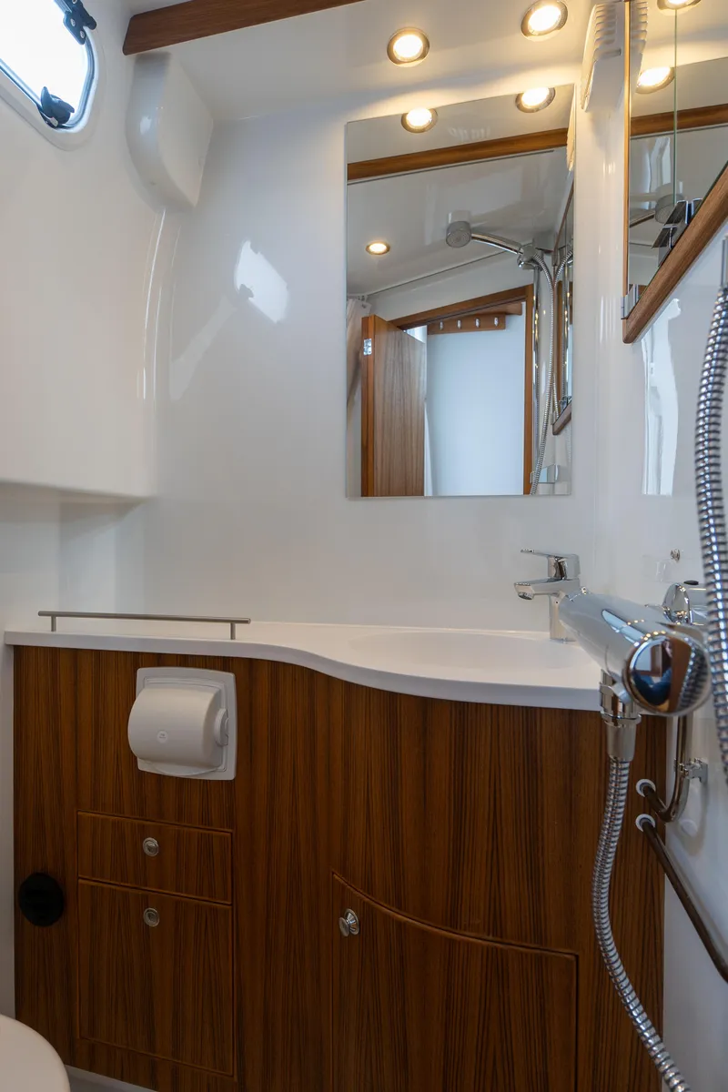 Slide: The Image of Das Bild zeigt ein modernes Badezimmer auf einem Boot mit Holzverkleidung und eleganter Beleuchtung. - 48