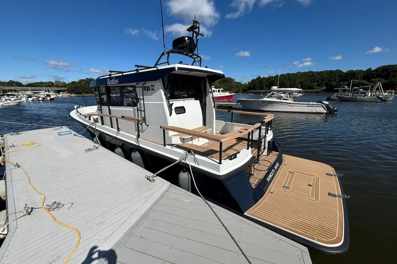 Slide: The Image of 2024 Targa 32 boat docked at marina under clear blue sky. - 14