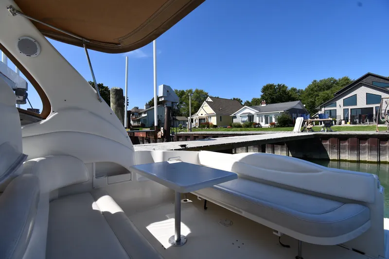 Slide: The Image of 2002 Sea Ray 360 Sundancer interior with dockside view and residential backdrop. - 16