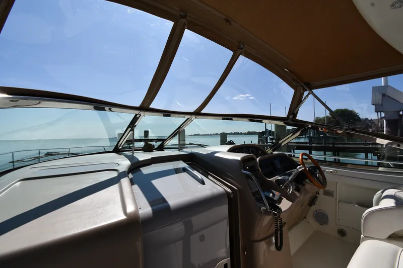 Slide: The Image of Interior view of 2002 Sea Ray 360 Sundancer yacht cockpit with waterfront backdrop. - 9