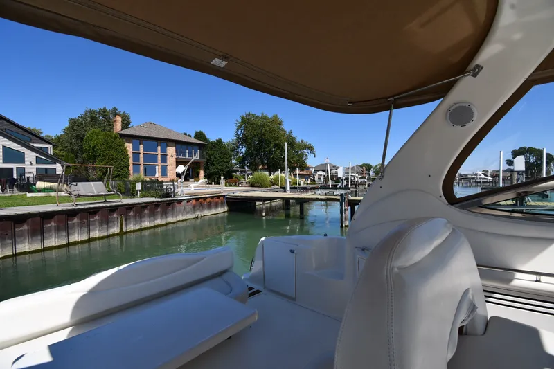 Slide: The Image of 2002 Sea Ray 360 Sundancer docked near waterfront homes under clear blue sky. - 15