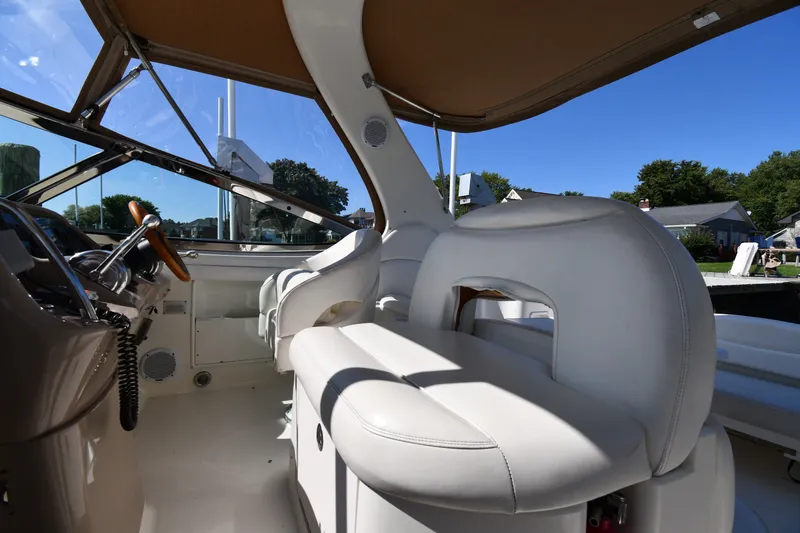 Slide: The Image of Interior view of 2002 Sea Ray 360 Sundancer yacht with white seating and steering wheel. - 12