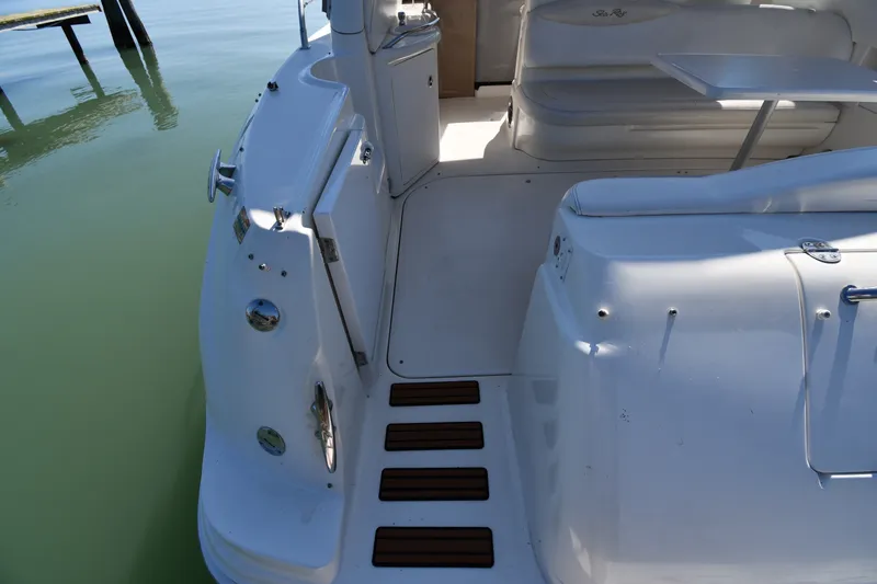 Slide: The Image of 2002 Sea Ray 360 Sundancer boat deck with seating and table, docked on calm water. - 17