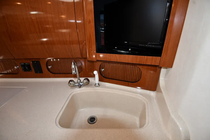Slide: The Image of Interior of 2002 Sea Ray 360 Sundancer with sink and TV in wooden cabinetry. - 29