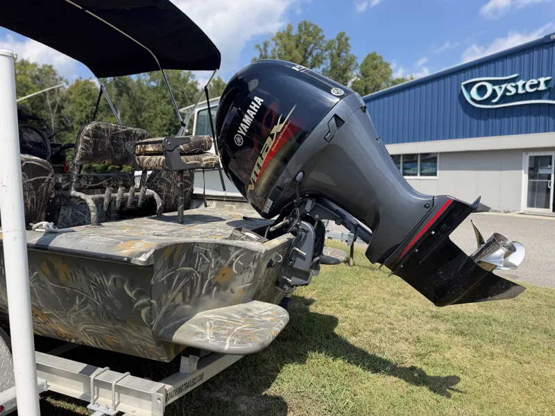 Slide: The Image of A War Eagle 2170 Blackhawk boat with a Yamaha outboard motor, parked on grass in front of a building. - 6