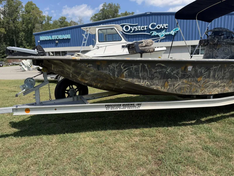 Slide: The Image of A 2023 War Eagle 2170 Blackhawk boat on a trailer, in front of a building with "Oyster Cove" signage. - 2