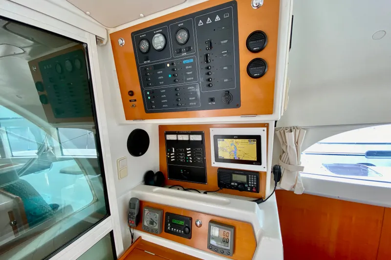 Slide: The Image of Control panel of a 2005 Lagoon 380 S2 catamaran, featuring navigation and communication equipment. - 82