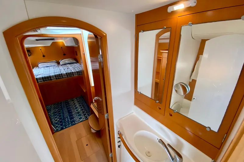 Slide: The Image of Interior of 2005 Lagoon 380 S2 yacht showing bedroom and bathroom with wooden finishes. - 78