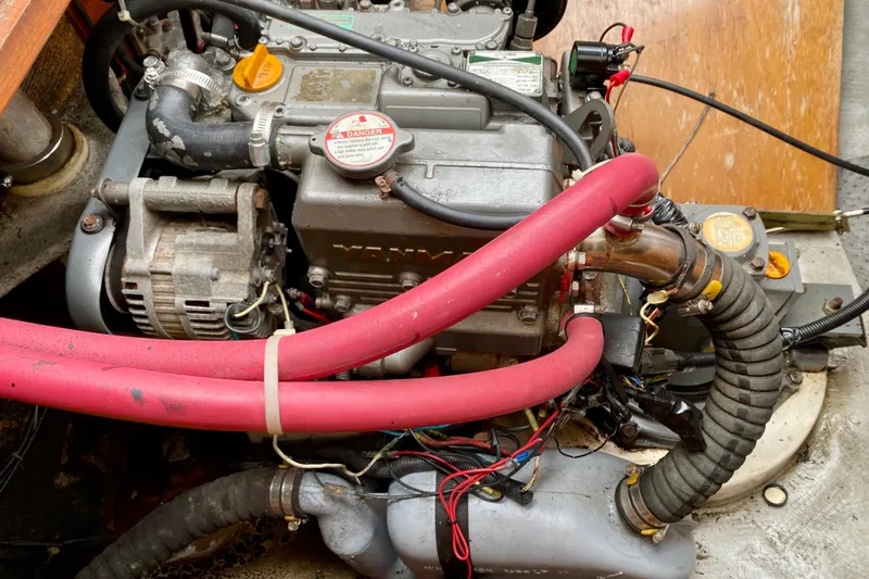Slide: The Image of Engine compartment of a 2005 Lagoon 380 S2 with visible red hoses and components. - 106