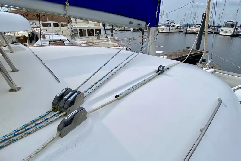 Slide: The Image of Deck view of a 2005 Lagoon 380 S2 catamaran docked at a marina. - 22