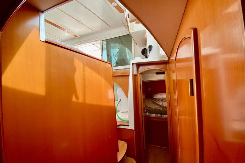 Slide: The Image of Interior of 2005 Lagoon 380 S2 catamaran with wooden paneling and cozy cabin space. - 90