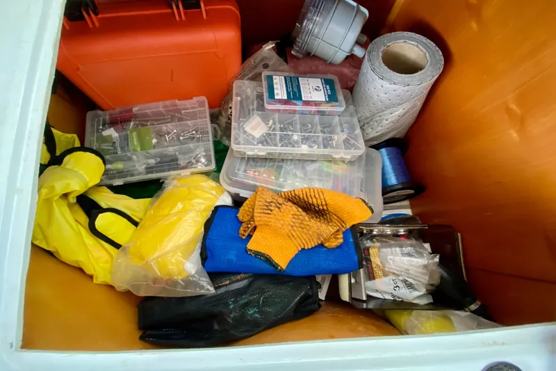 Slide: The Image of Storage compartment on a 2005 Lagoon 380 S2 with tools, gloves, and supplies. - 137