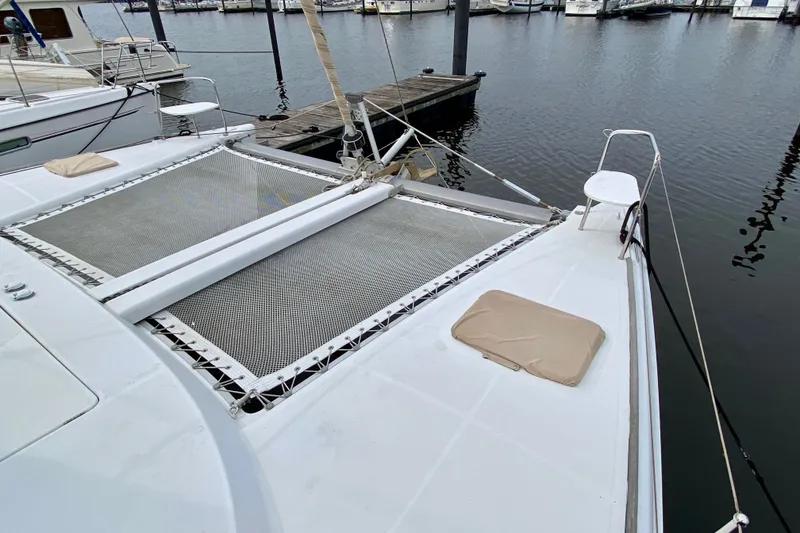 Slide: The Image of Catamaran Lagoon 380 S2, 2005 model, docked at marina with visible netting and deck. - 15