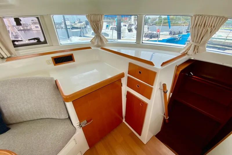 Slide: The Image of Interior of 2005 Lagoon 380 S2 catamaran with wood accents and marina view. - 47