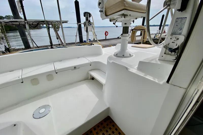 Slide: The Image of Cockpit of 2005 Lagoon 380 S2 catamaran with helm and seating, dockside view. - 31
