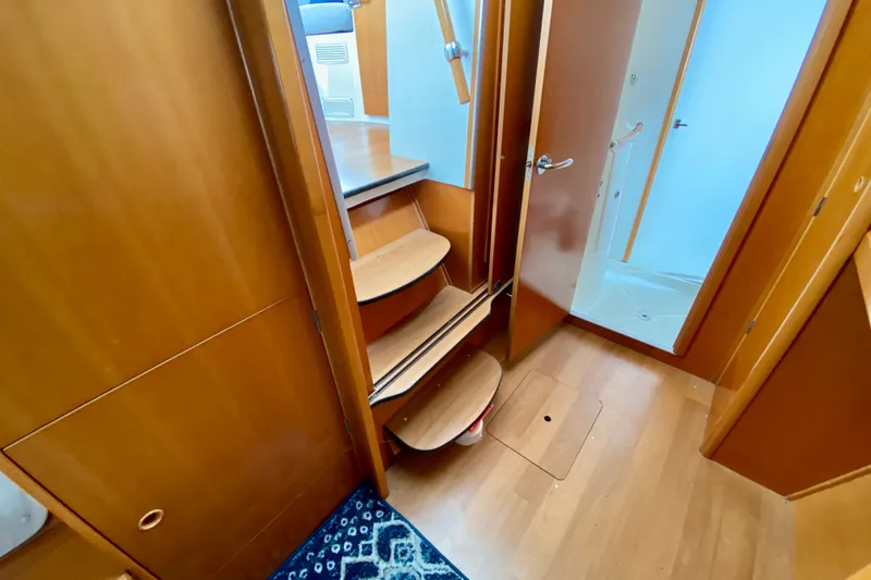 Slide: The Image of Interior of 2005 Lagoon 380 S2 yacht, featuring wooden stairs and a compact bathroom. - 72
