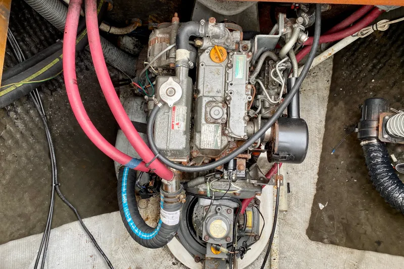 Slide: The Image of Engine compartment of a 2005 Lagoon 380 S2 catamaran with visible hoses and components. - 98