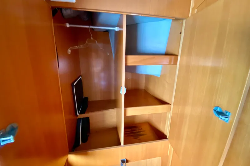 Slide: The Image of Wooden storage cabinet inside 2005 Lagoon 380 S2 yacht, featuring shelves and hangers. - 114