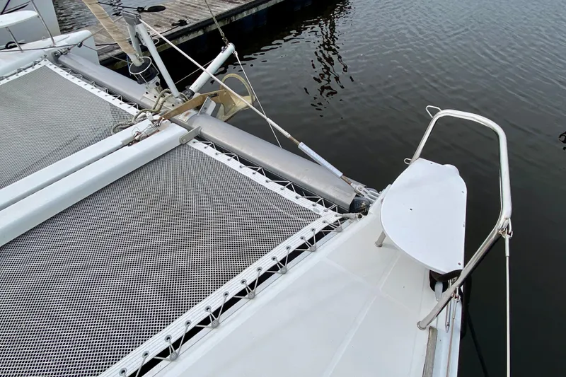 Slide: The Image of Bow of 2005 Lagoon 380 S2 catamaran with netting and dock view. - 16