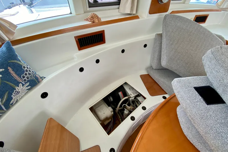 Slide: The Image of Interior view of a 2005 Lagoon 380 S2 yacht, showcasing seating and storage area. - 138