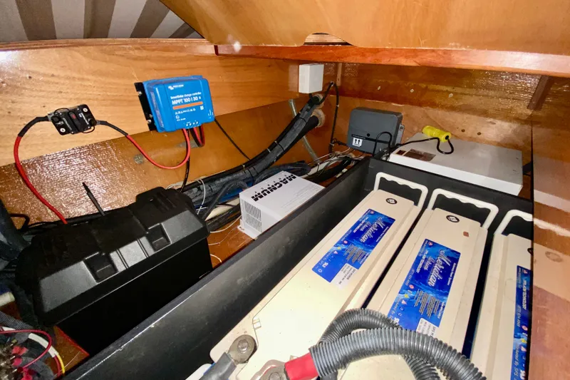 Slide: The Image of Electrical system inside a 2005 Lagoon 380 S2 yacht, featuring batteries and wiring components. - 119