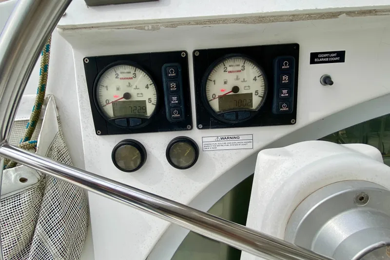 Slide: The Image of Control panel of a 2005 Lagoon 380 S2 catamaran with gauges and warning labels. - 143