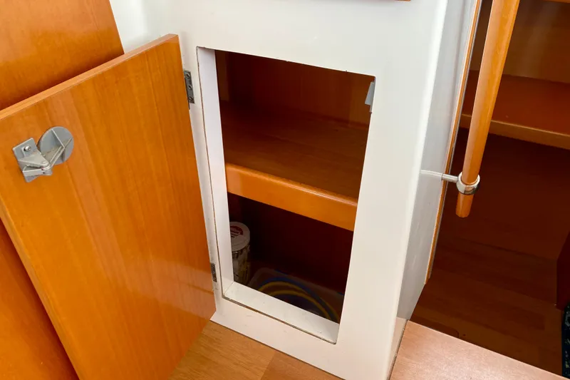 Slide: The Image of Open wooden cabinet on 2005 Lagoon 380 S2 yacht interior. - 130