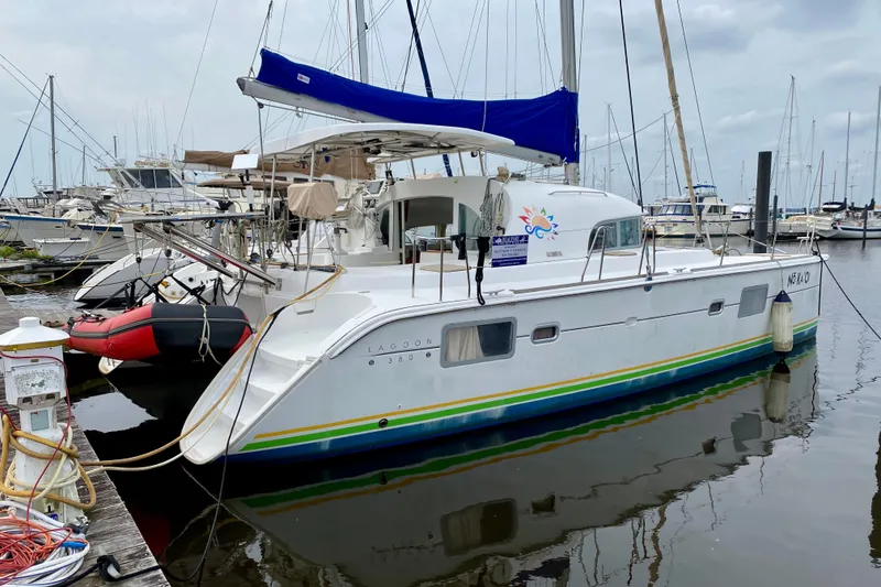 Slide: The Image of 2005 Lagoon 380 S2 catamaran docked in a marina with blue sail cover. - 3