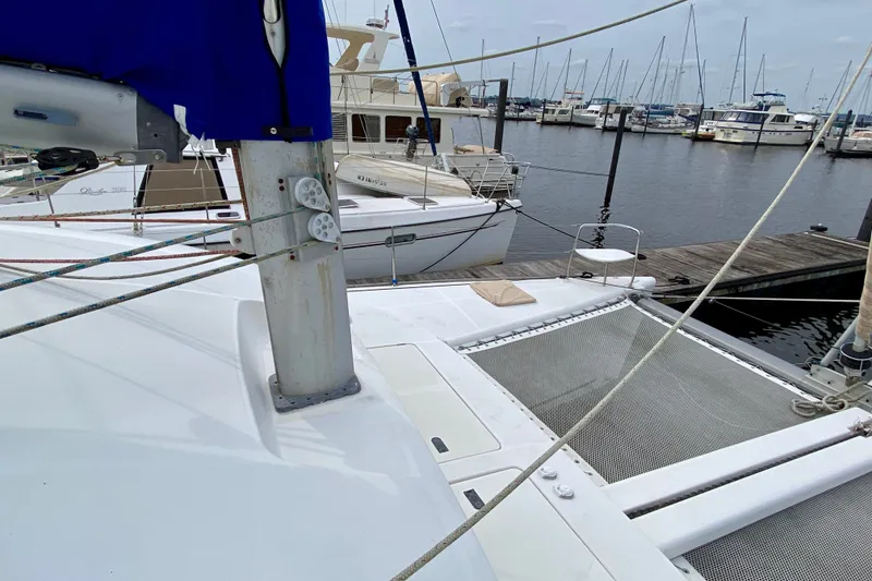 Slide: The Image of 2005 Lagoon 380 S2 catamaran docked at a marina with other boats. - 23