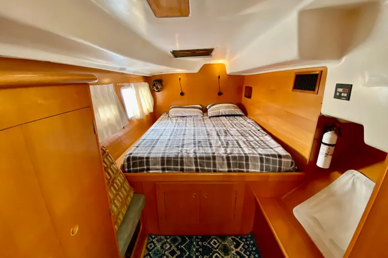 Slide: The Image of Cozy cabin interior of 2005 Lagoon 380 S2 catamaran with double bed and wooden finish. - 70
