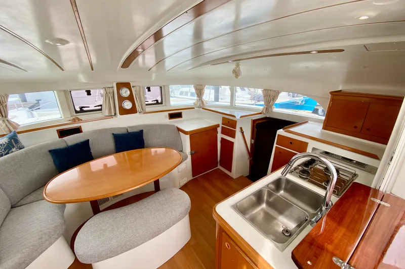 Slide: The Image of Interior of 2005 Lagoon 380 S2 catamaran with dining area and kitchen. - 54