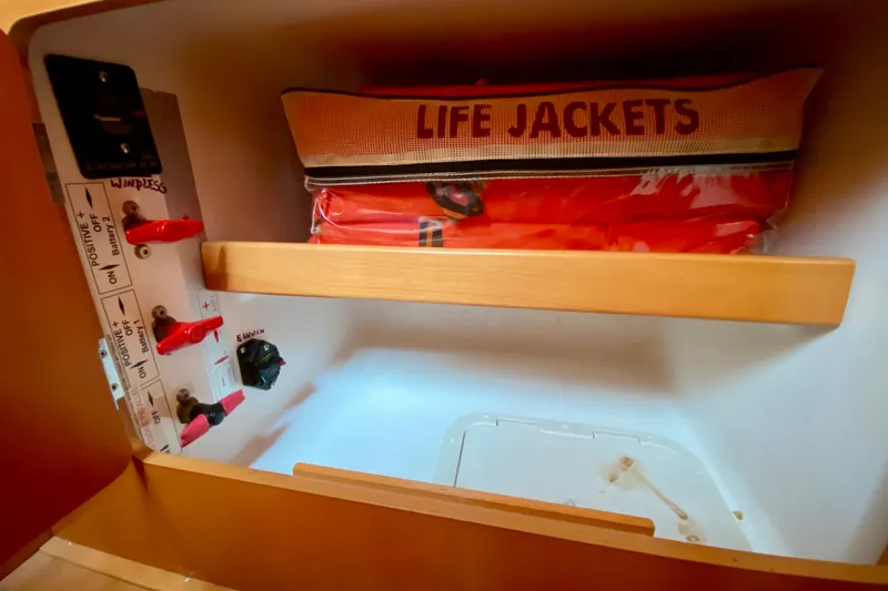 Slide: The Image of Storage compartment with life jackets and electrical panel on a 2005 Lagoon 380 S2. - 116