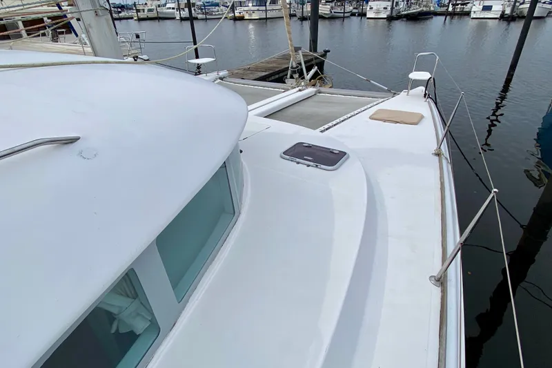 Slide: The Image of 2005 Lagoon 380 S2 catamaran docked at marina, showcasing deck and cabin windows. - 14