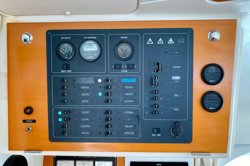 Slide: The Image of Control panel of a 2005 Lagoon 380 S2 catamaran, featuring gauges and switches. - 83
