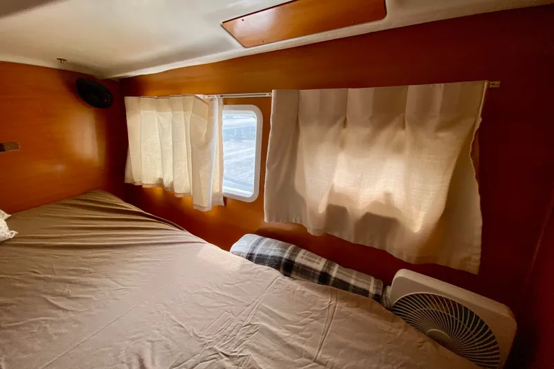 Slide: The Image of Cozy cabin interior of 2005 Lagoon 380 S2 with bed, window, and fan. - 93