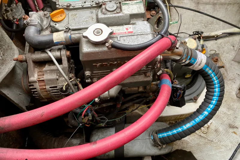 Slide: The Image of Engine compartment of a 2005 Lagoon 380 S2 with visible hoses and components. - 100