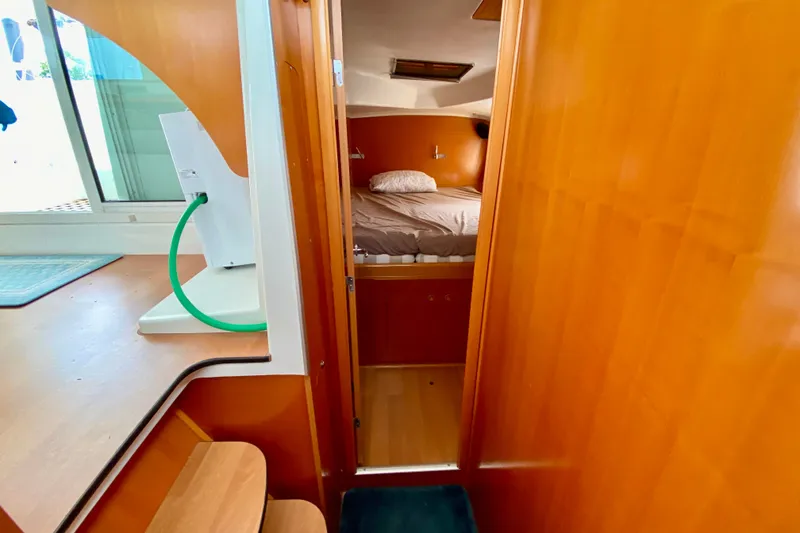 Slide: The Image of Interior view of 2005 Lagoon 380 S2 catamaran cabin with wooden finish and cozy bed. - 91