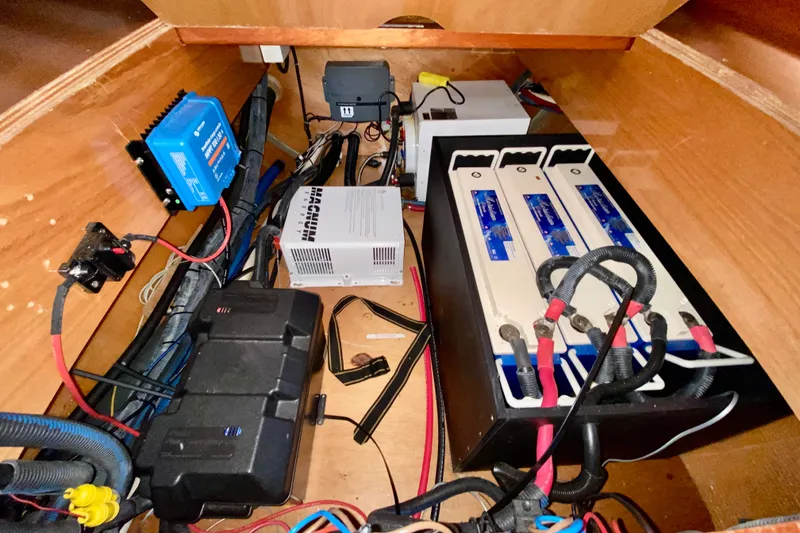 Slide: The Image of Electrical system setup in a 2005 Lagoon 380 S2 catamaran, featuring batteries and wiring. - 117