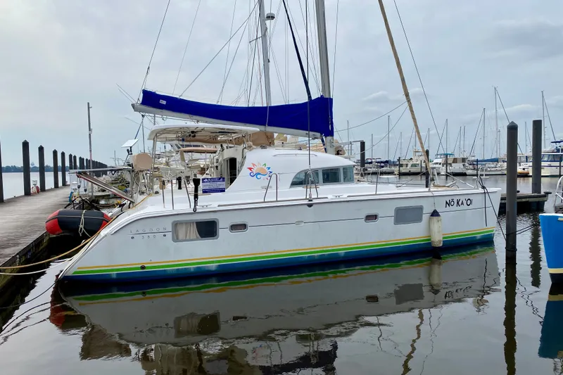 Slide: The Image of 2005 Lagoon 380 S2 catamaran docked at marina with blue sail cover. - 4
