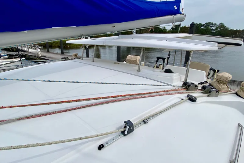 Slide: The Image of 2005 Lagoon 380 S2 sailboat deck with ropes and covered boom at marina. - 28