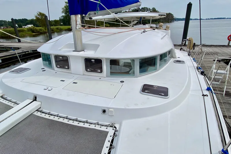 Slide: The Image of 2005 Lagoon 380 S2 catamaran docked, showcasing sleek design and spacious deck. - 26