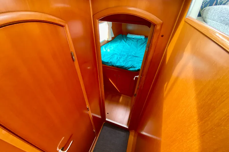 Slide: The Image of Interior cabin view of 2005 Lagoon 380 S2 yacht with wooden finish and cozy bed. - 87