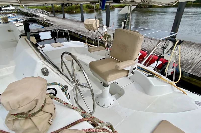Slide: The Image of Helm station of 2005 Lagoon 380 S2 catamaran with steering wheel and seating. - 38